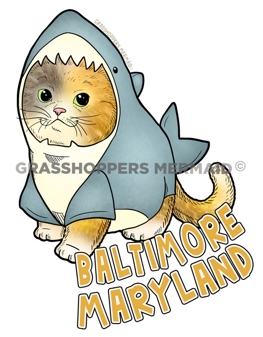 A funny sticker of an orange fluffy cat wearing a blue shark costume with "Baltimore Maryland" written in yellow-outlined letters.